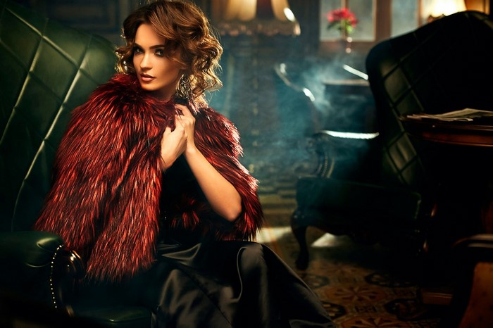 Woman in red fur coat sitting in armchair