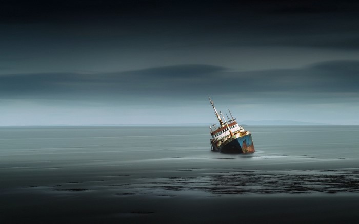 Sunken ship on a calm sea under cloudy sky