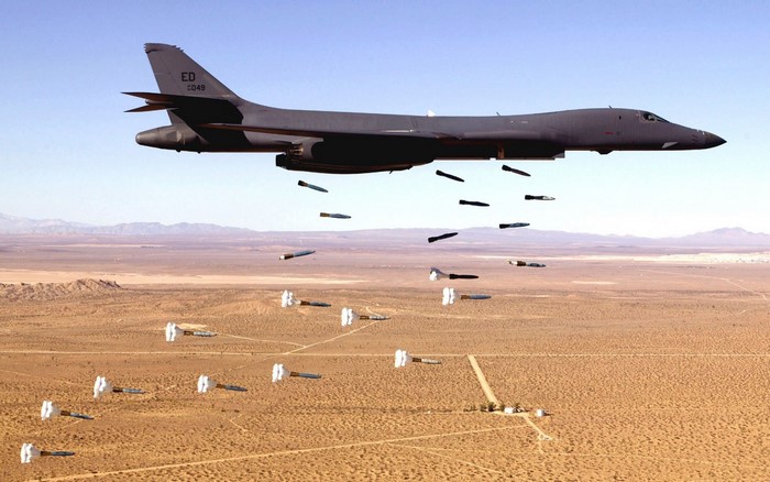 Rockwell B-1 Lancer bomber dropping bombs over desert