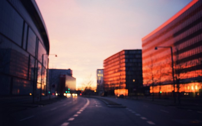 Blurred cityscape at sunset with modern buildings and street lights