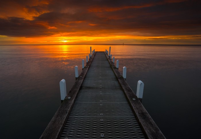 Pier extending into the ocean at sunset