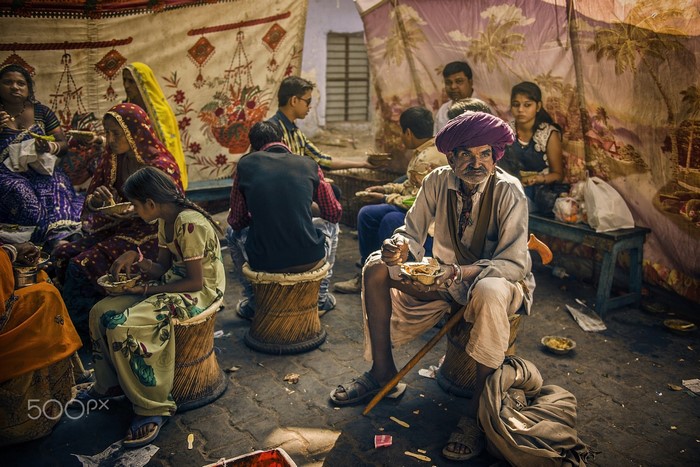 People gathered for a meal in a traditional setting