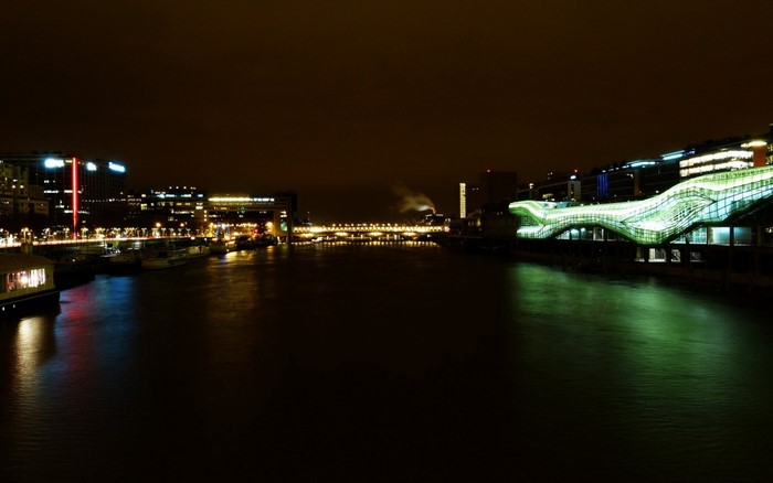 Cityscape at night with river and illuminated buildings