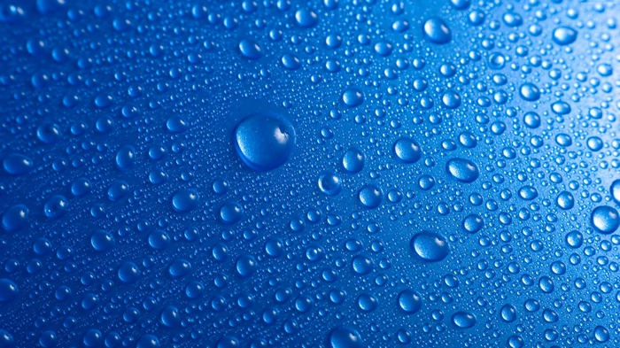 Macro view of water drops on a blue surface