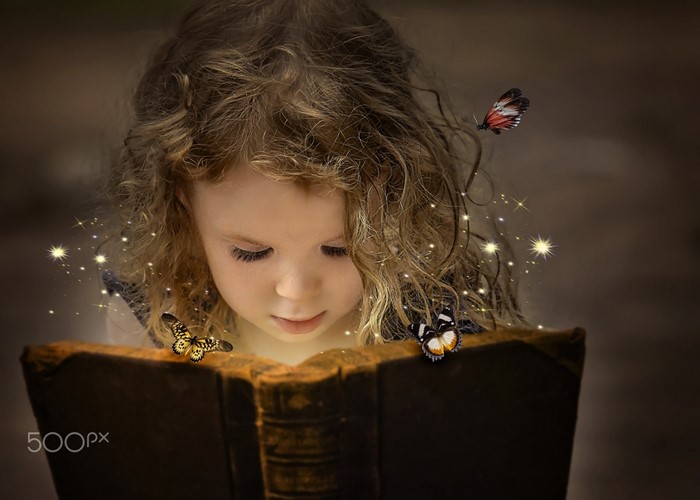 Girl reading a magical book with butterflies