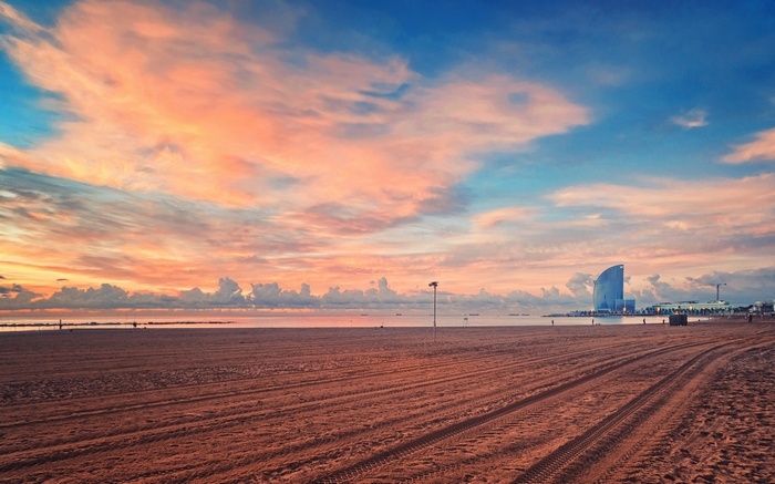 Beach at sunset with a modern building