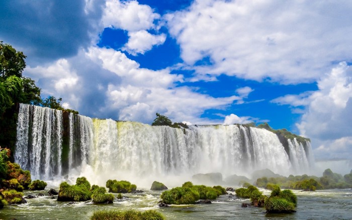 Wide waterfall cascading over rocks with green vegetation