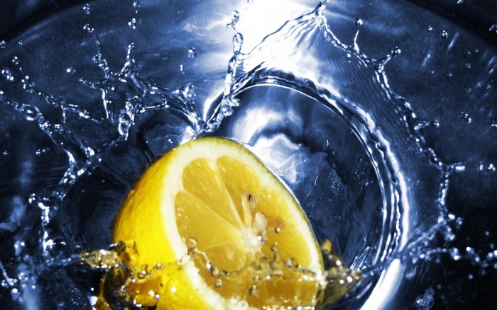 Lemon slice splashing into water