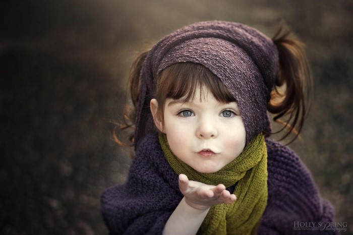 Close-up portrait of a young girl blowing a kiss
