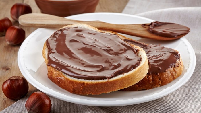 Bread slices with chocolate hazelnut spread and hazelnuts