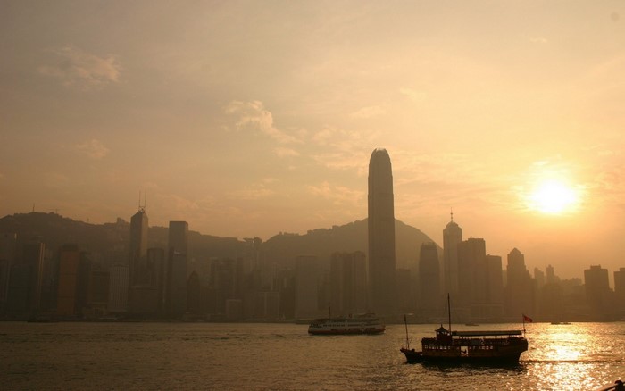 Hong Kong skyline at sunset with boats in the harbor