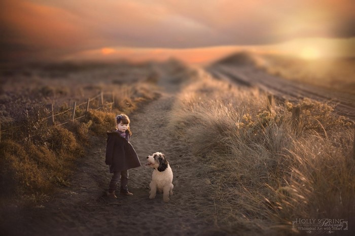 Girl and dog on a path at sunset