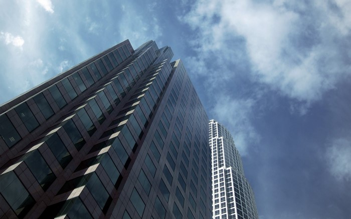 Two skyscrapers against a cloudy blue sky