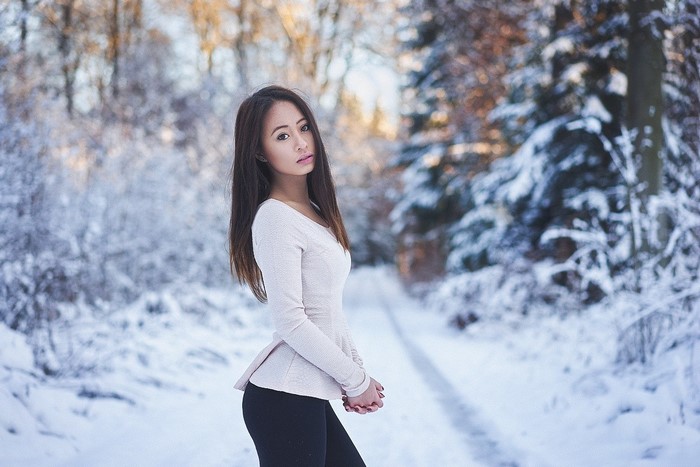 Asian woman with long hair in a snowy forest