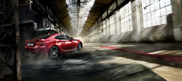 Red Toyota GT 86 drifting in an abandoned warehouse