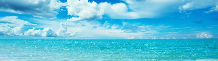 Turquoise ocean under a cloudy blue sky