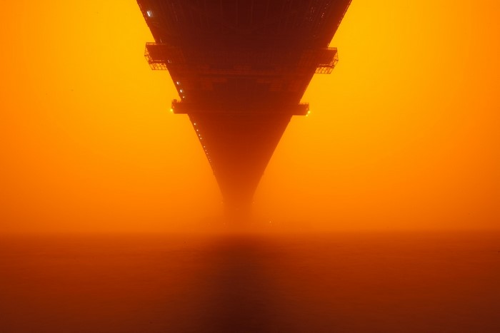 Bridge over water in orange mist