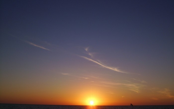 Sunset over the ocean with wispy clouds
