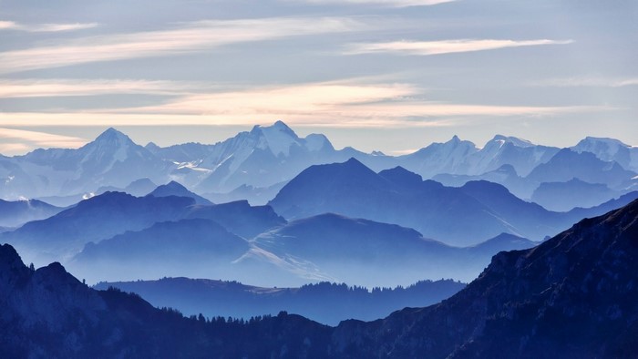 Layered blue mountains under a pale sky