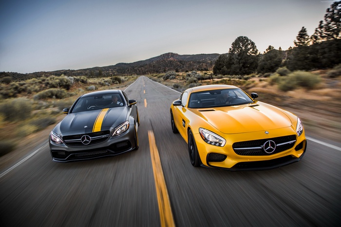 Two Mercedes-AMG cars driving on a desert road