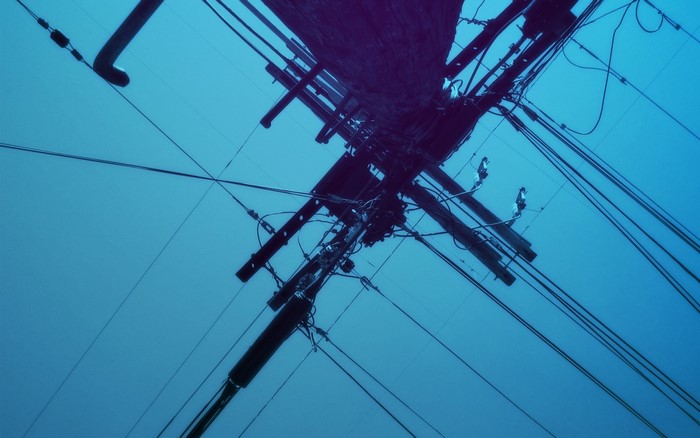 Overhead power lines against a blue sky