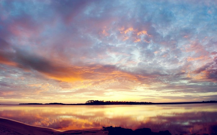 Sunset over the water with colorful clouds