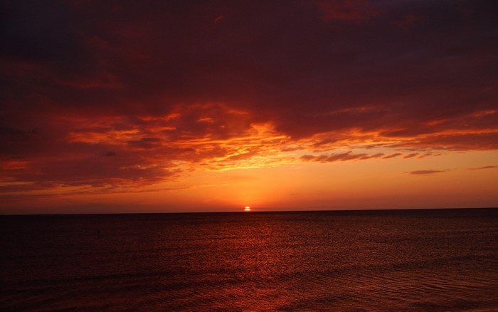 Sunset over the ocean with dramatic clouds
