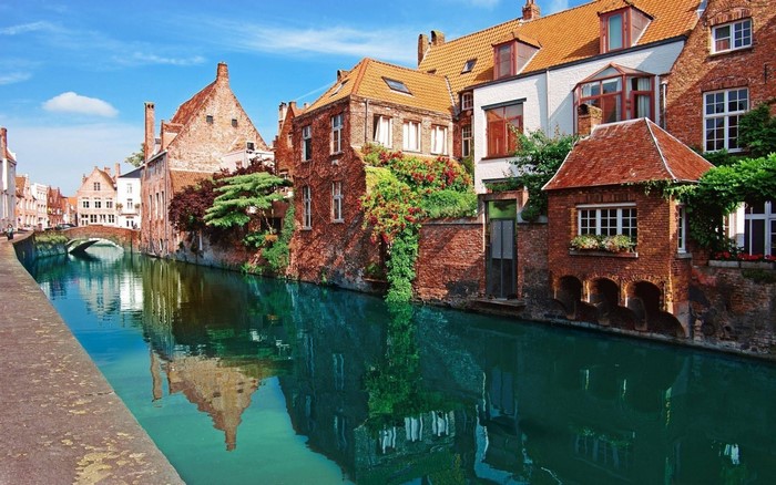 Bruges canal with historic brick buildings and reflections