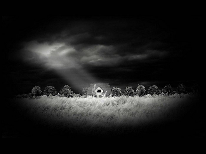 Monochrome house in a field with dramatic clouds