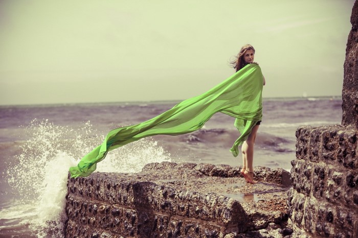Woman with green scarf on a rocky shore