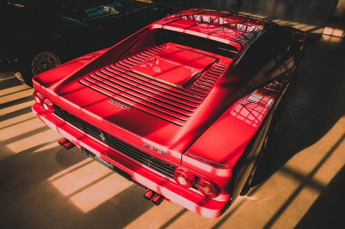 Red Ferrari Testarossa parked indoors with sunlight