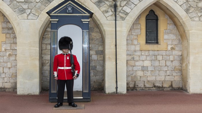 Guard in Red Uniform Standing by Guardhouse