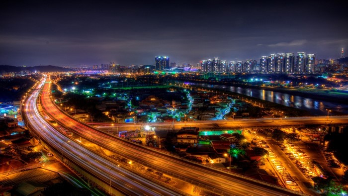 Cityscape at night with highway and river