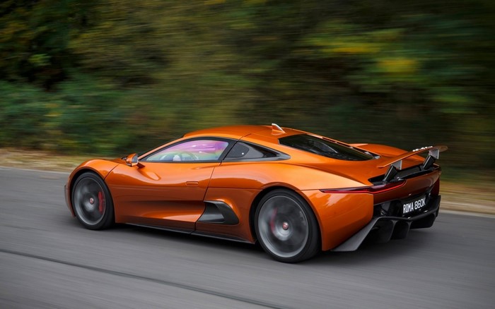 Orange Jaguar C-X75 sports car driving on a road