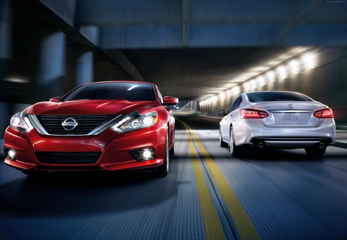 Red and silver Nissan Altimas driving in tunnel
