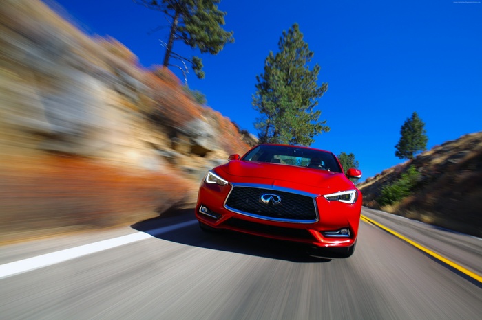 Red Infiniti Q60 Red Sport 400 driving on a road