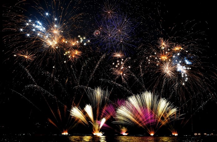 Fireworks display over a body of water at night