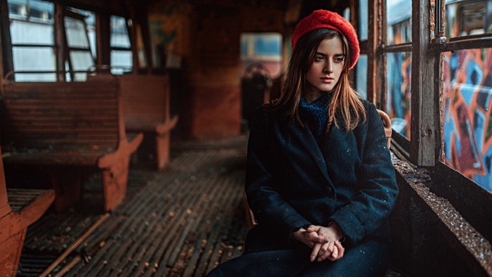 Woman in red beret and blue coat in abandoned train car