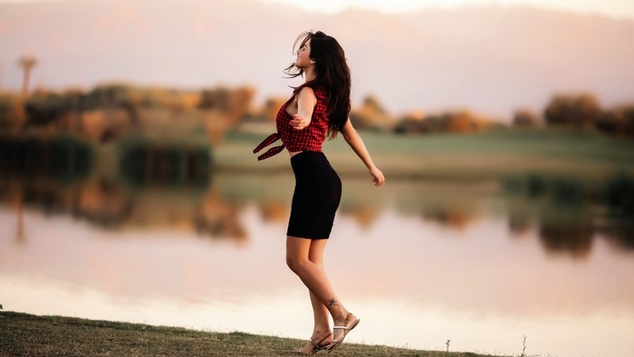 Woman Dancing by a Tranquil Lake at Sunrise