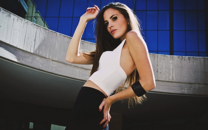 Woman posing in a white top and black skirt