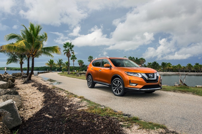 Orange Nissan Rogue SL crossover on a coastal road