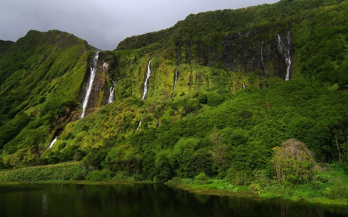 Green mountains with waterfalls flowing into a lake