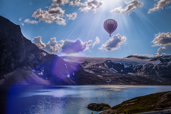 Hot air balloon over a lake and mountains in Norway