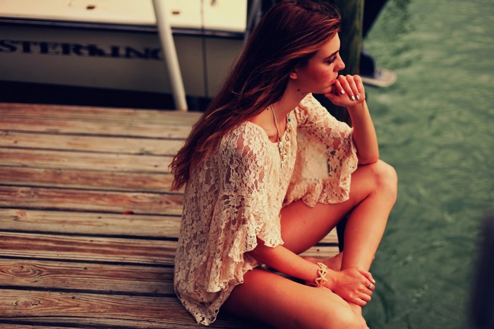 Contemplative Woman Sitting by the Lake on a Wooden Dock