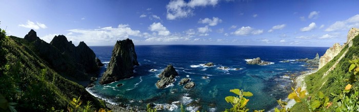 Panoramic view of a rocky coastline with jagged sea stacks