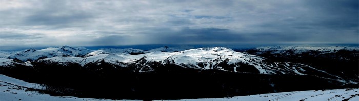 Snowy mountain range under a cloudy sky