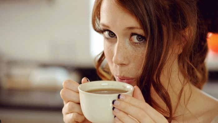 Redhead woman drinking from a cup