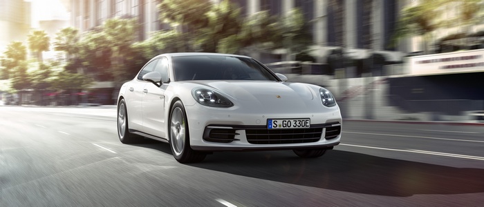 White Porsche Panamera 4 E-Hybrid driving on city street