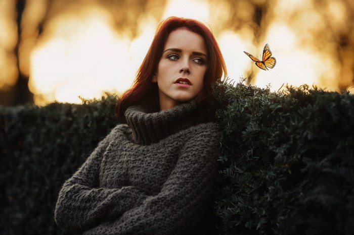 Woman with red hair and butterfly in sweater