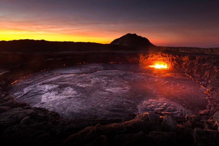 Lava lake at sunset with mountain in Ethiopia